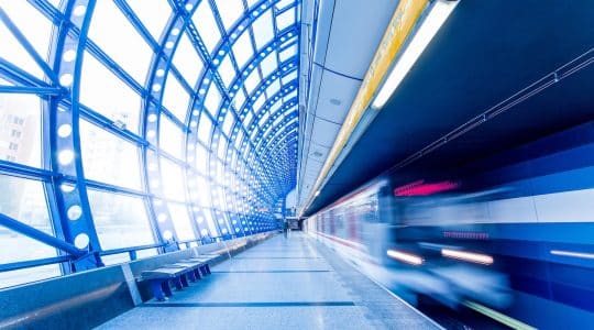 A commuter train passes a platform